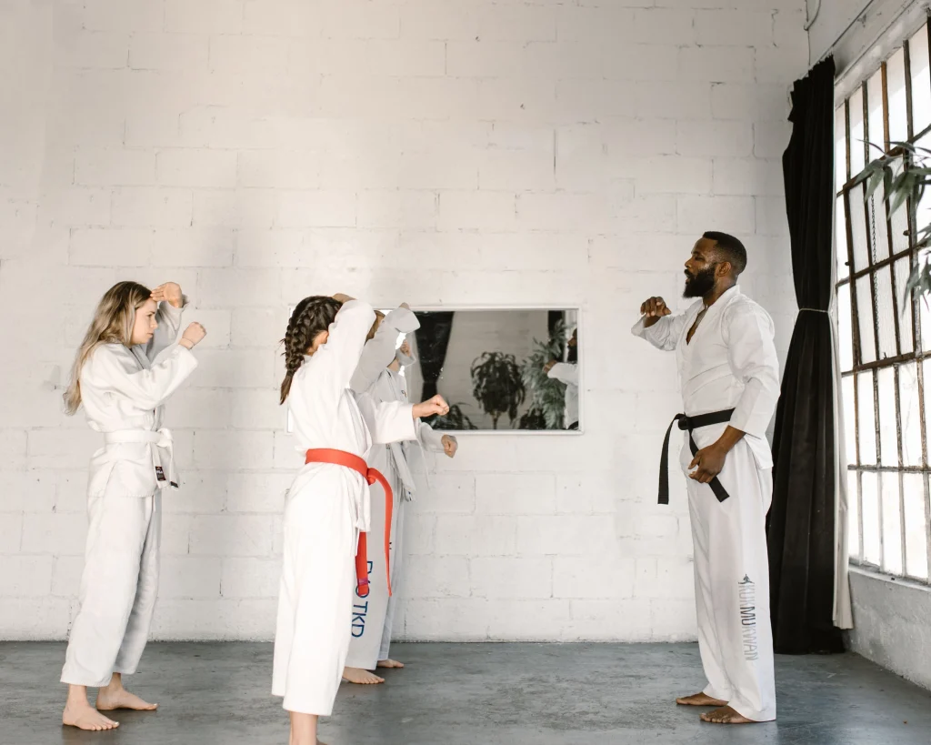Enfants qui suivent un cours d’arts martiaux sous la direction d’un instructeur